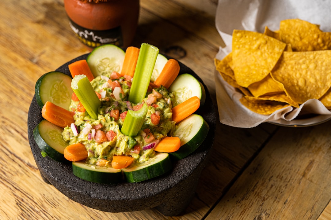 a-bowl-of-vegetables-and-tortilla-chips-on-a-wooden-table-anrm3f4opka